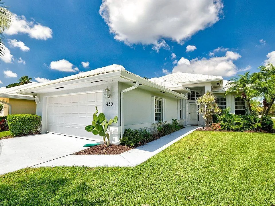 Seamless white aluminum K-style gutters and downspout drainage system installed along the fascia of a single-story tile-roof residence in Lakeland, FL