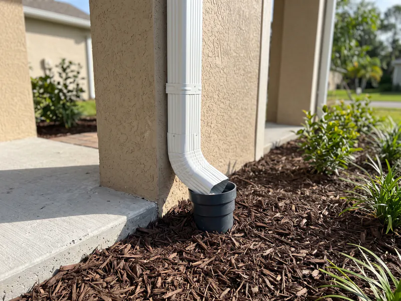 Oversized 3x4-inch aluminum downspout installation connected to underground drainage pipe in Haines City FL